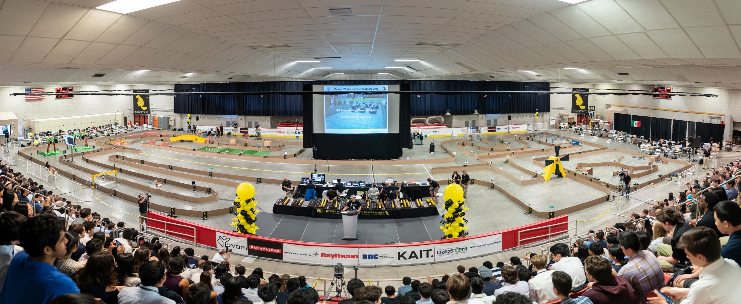 Robert Shin speaks to attendees of this year's Beaver Works Summer Institute final event with the RACECAR obstacle course in the background. Photo: Glen Cooper