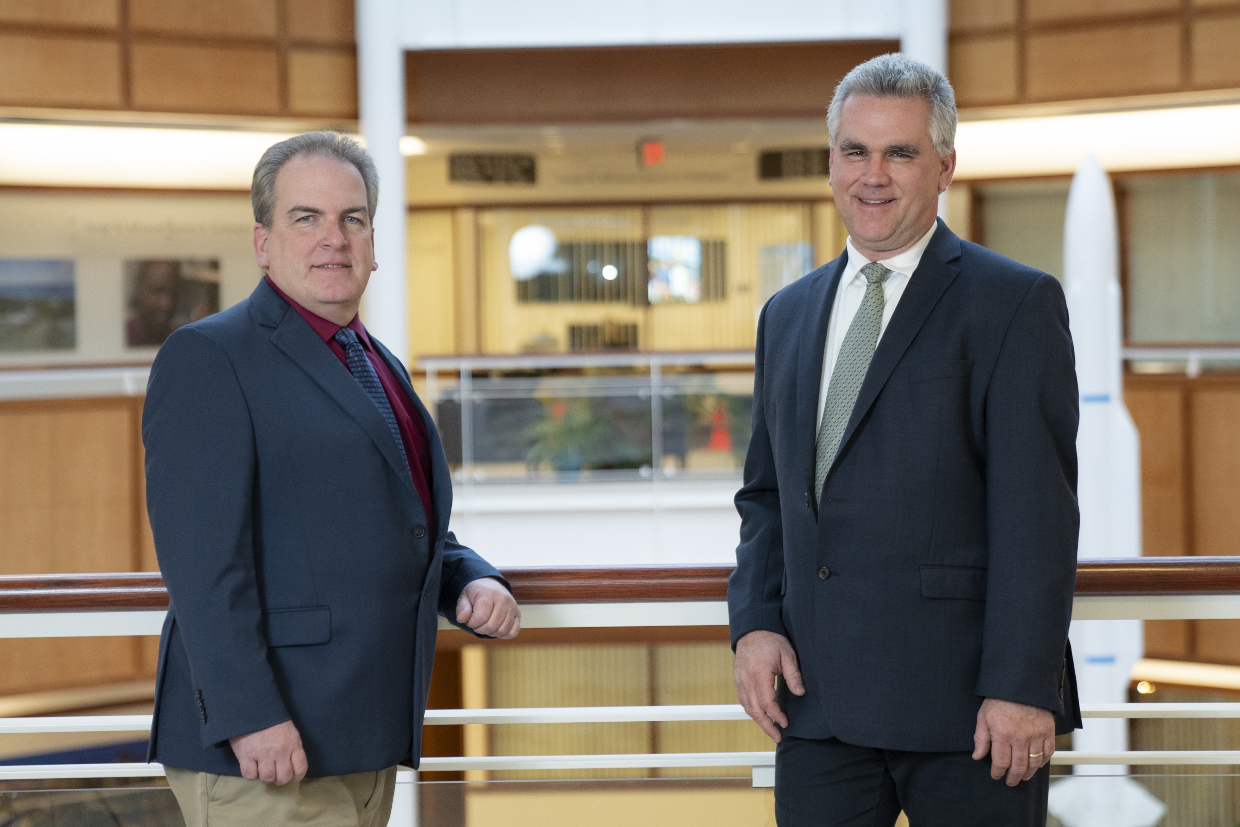 Two staff members pose for a photo in the Laboratory atrium. 