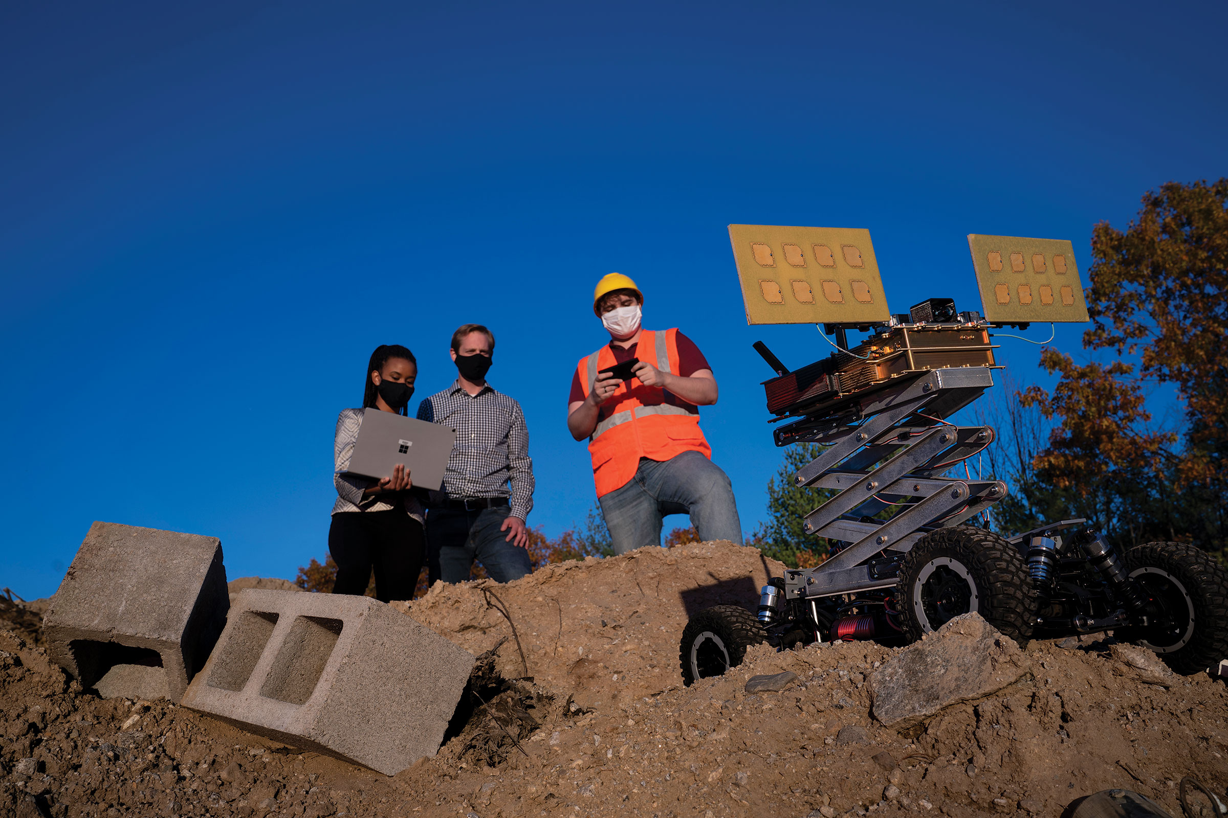 Photo of the MURMUR sensor integrated on an unmanned ground vehicle. Operators behind mobile vehicle remotely control the system.