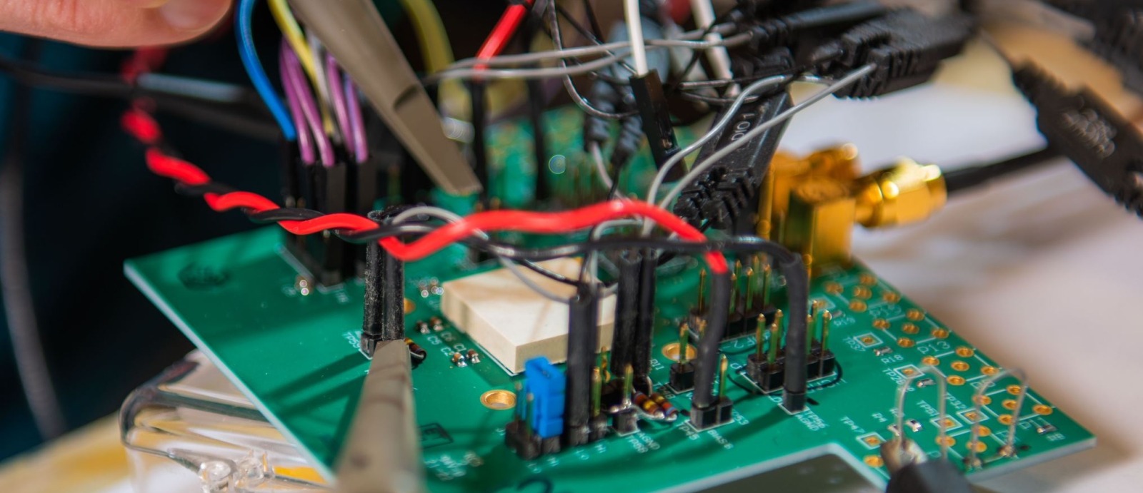 A close up photo of an integrated circuit board with connected wires. 