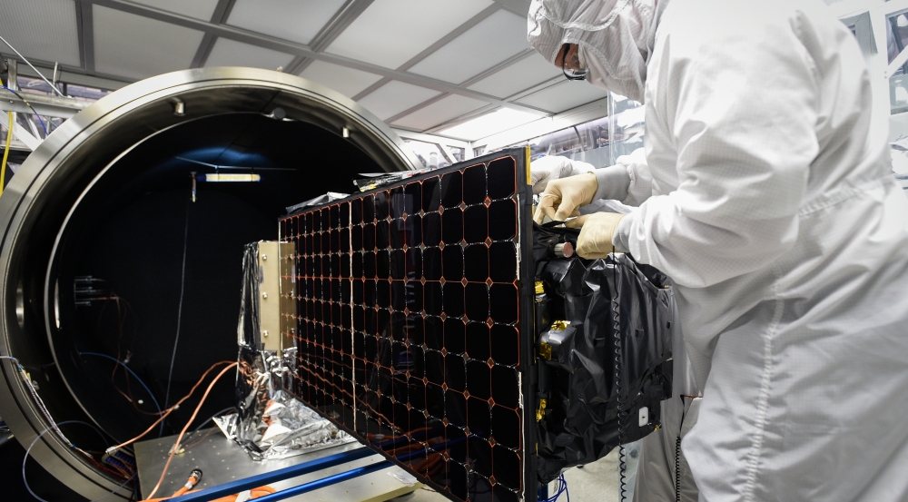 An engineer is installing SensorSat in the thermal-vacuum chamber used for testing the satellite's tolerance of conditions in space. Photo: Glen Cooper