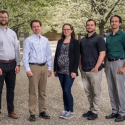 Five staff members pose for a group photo. 