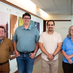 Four staff members smile for a group photo.