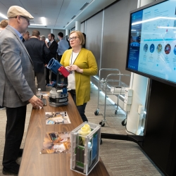 Two people talk at a poster presentation session.