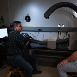 Three project team members test the robot's flexibility in an indoor laboratory setting. 