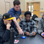 David Langus Rodriguez of Lincoln Laboratory helps three students use development boards.